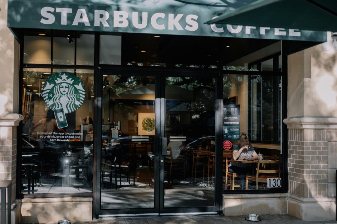 A man sitting behind his laptop in a Starbucks store